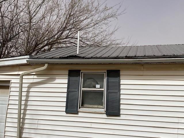 view of side of property featuring metal roof and a garage