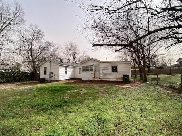 back of house featuring a yard and fence