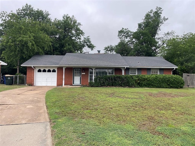 ranch-style house with fence, driveway, an attached garage, a front lawn, and brick siding