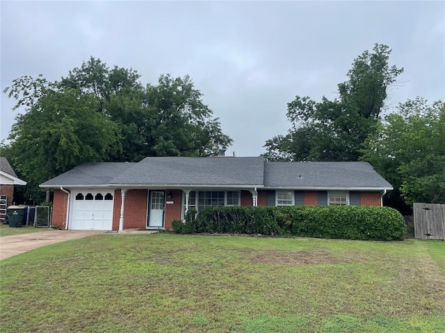 ranch-style house with a front yard, fence, driveway, a garage, and brick siding