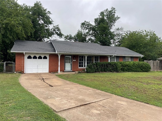 ranch-style house featuring a front yard, concrete driveway, fence, and a garage