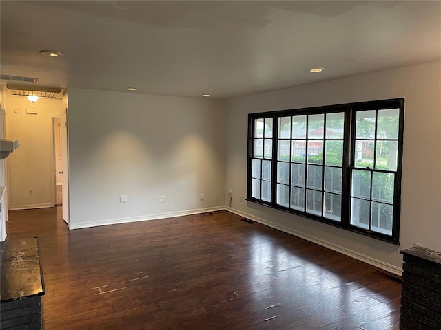 unfurnished room with dark wood-style floors, visible vents, recessed lighting, and baseboards