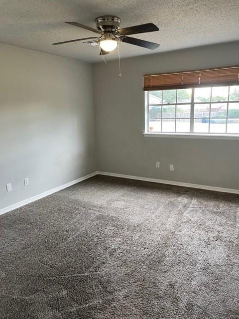 carpeted spare room featuring baseboards, a textured ceiling, and a ceiling fan