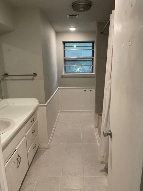 bathroom featuring a shower with shower curtain, visible vents, and vanity