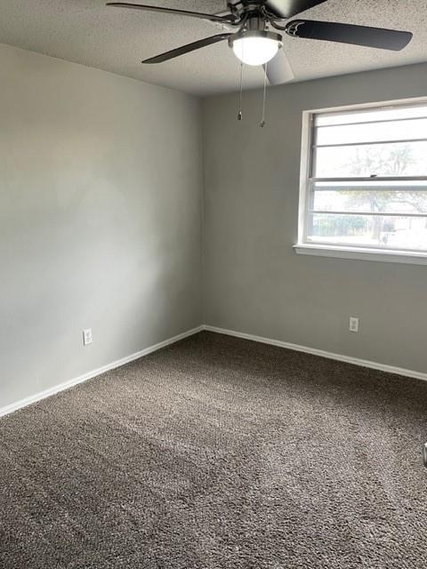 spare room featuring baseboards, carpet floors, a textured ceiling, and a ceiling fan