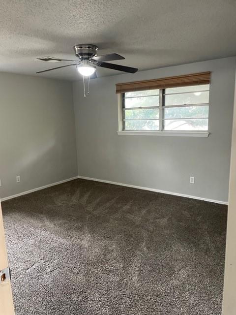 carpeted spare room with a textured ceiling, baseboards, and a ceiling fan