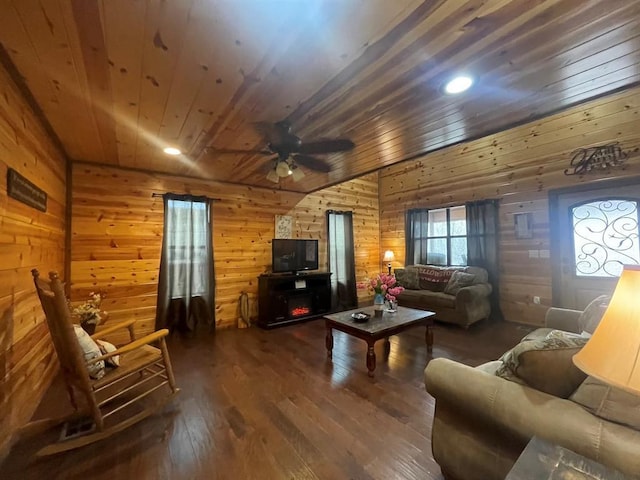 living area featuring wooden ceiling, wooden walls, a ceiling fan, and dark wood-type flooring