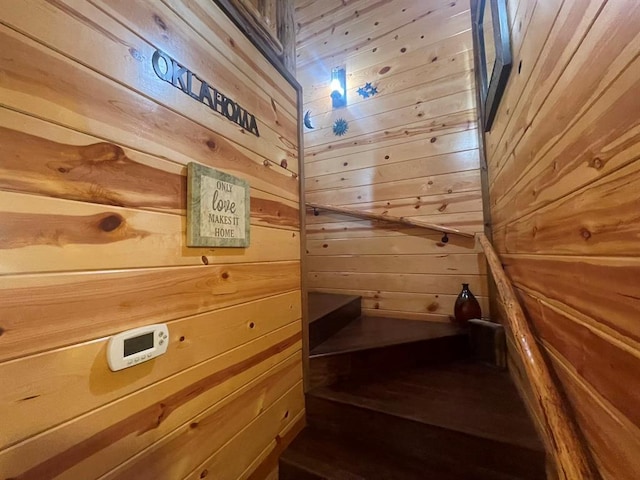 stairs featuring wood walls