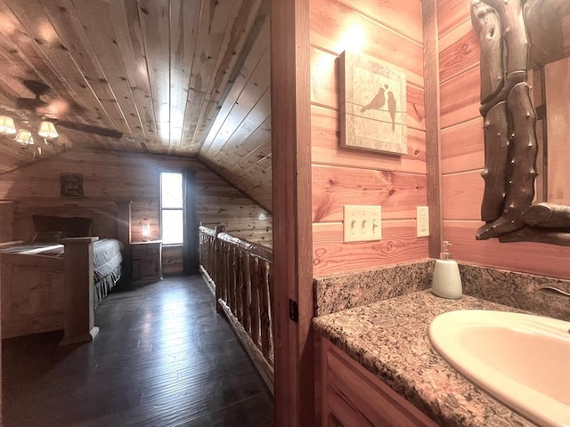 bathroom with a ceiling fan, wood finished floors, wooden walls, wood ceiling, and vaulted ceiling