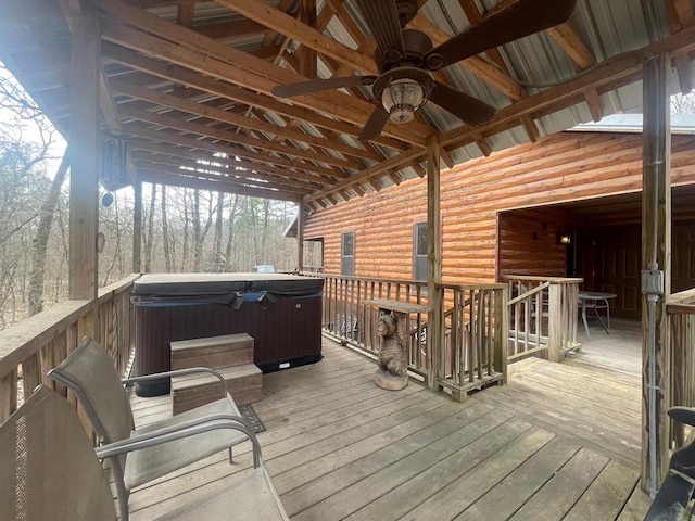 wooden terrace with a ceiling fan and a hot tub