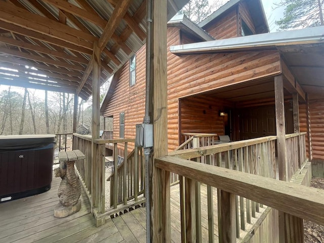 wooden terrace with an exterior structure, a hot tub, and an outdoor structure