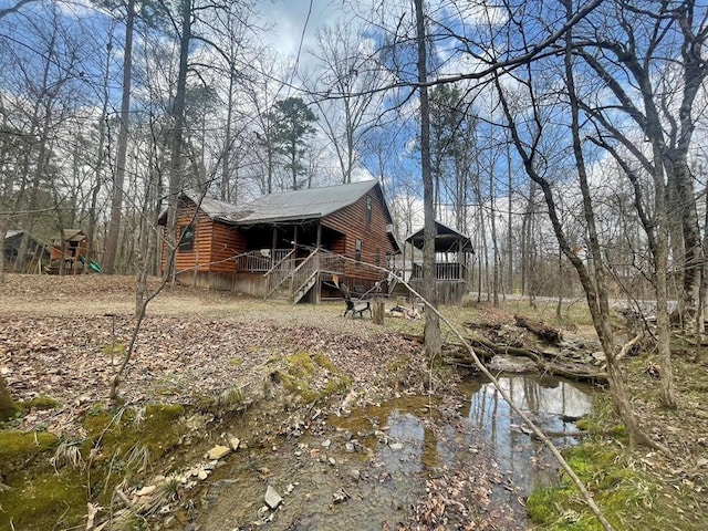 exterior space featuring a porch and faux log siding