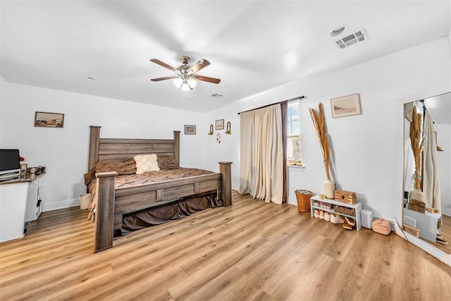 bedroom with visible vents, light wood-style flooring, baseboards, and ceiling fan