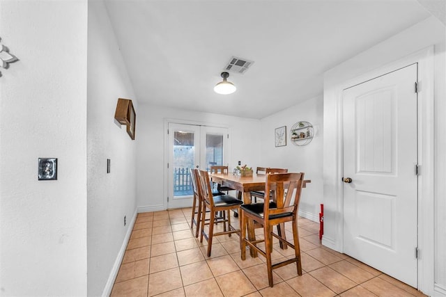 dining area featuring light tile patterned floors, french doors, visible vents, and baseboards