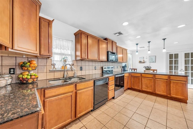 kitchen with brown cabinetry, visible vents, a peninsula, a sink, and black appliances