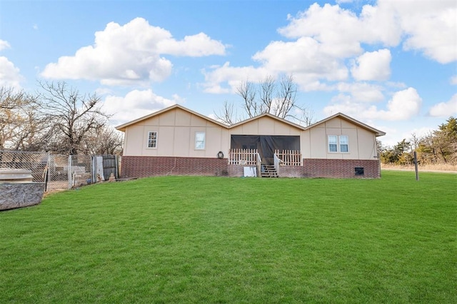 back of house featuring a gate, fence, a yard, and a sunroom