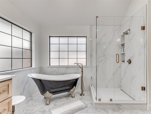 bathroom with vanity, a marble finish shower, a soaking tub, tile walls, and marble finish floor