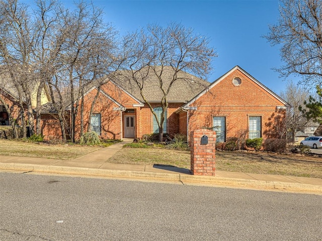 view of front of home with a front yard and brick siding