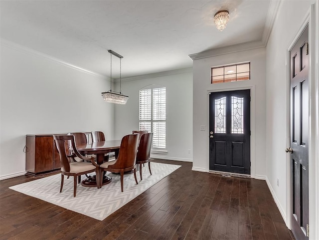 dining room with dark wood-type flooring, crown molding, and baseboards