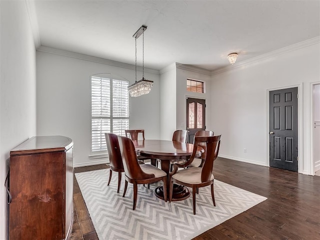 dining space with dark wood finished floors, a notable chandelier, baseboards, and ornamental molding