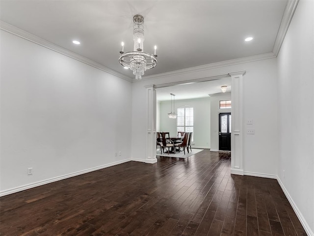 spare room featuring baseboards, wood finished floors, a chandelier, and ornamental molding