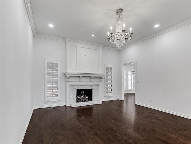 unfurnished living room featuring wood finished floors, baseboards, a fireplace, ornamental molding, and a chandelier