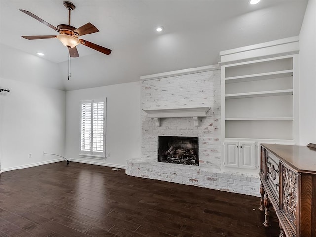 unfurnished living room with a brick fireplace, baseboards, ceiling fan, dark wood finished floors, and lofted ceiling