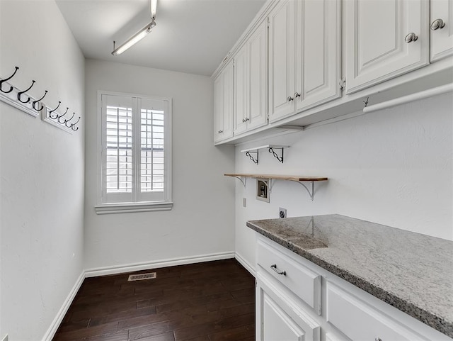 washroom featuring electric dryer hookup, visible vents, dark wood-type flooring, baseboards, and hookup for a washing machine