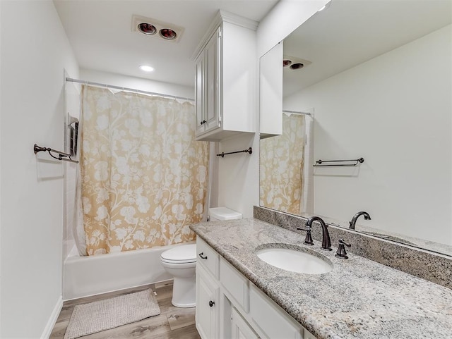 bathroom with vanity, wood finished floors, visible vents, shower / bath combination with curtain, and toilet