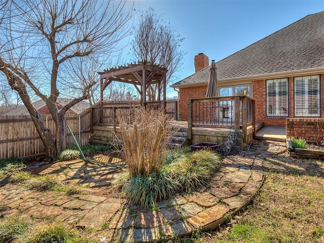 view of yard featuring a wooden deck, a pergola, and fence