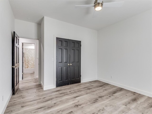 2809 Red Fern, Edmond, OK 73034 - unfurnished bedroom featuring light wood-style floors, a closet, and a ceiling fan
