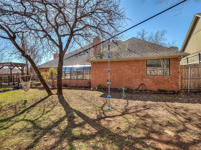 2809 Red Fern, Edmond, OK 73034 - back of property featuring brick siding, a chimney, and a sunroom