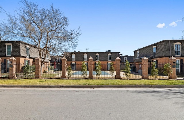 view of front of home with brick siding and a fenced front yard