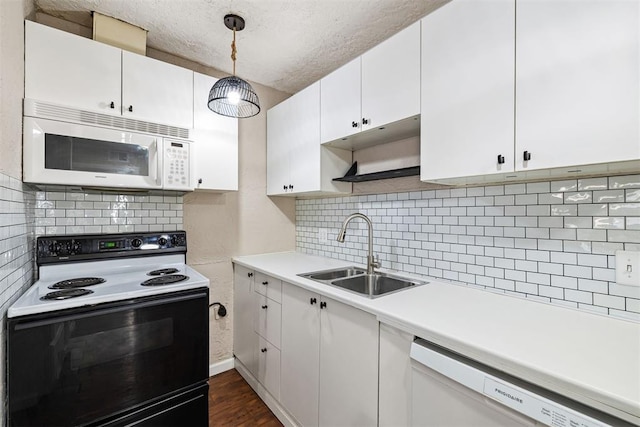 kitchen featuring white appliances, dark wood finished floors, a sink, light countertops, and white cabinetry