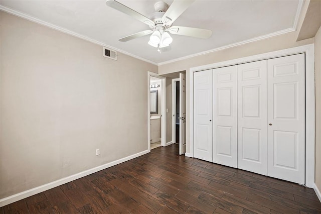 unfurnished bedroom featuring visible vents, ornamental molding, dark wood-style floors, a closet, and baseboards