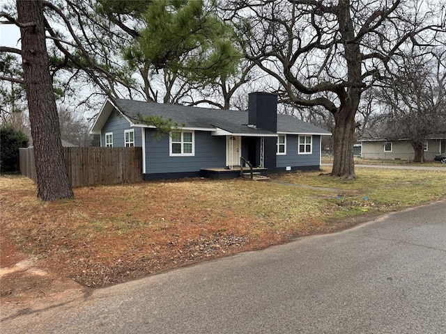 single story home featuring a chimney and fence