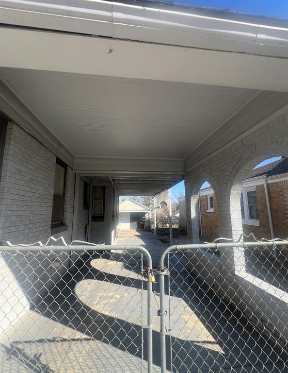 view of patio / terrace featuring a carport, fence, and a gate