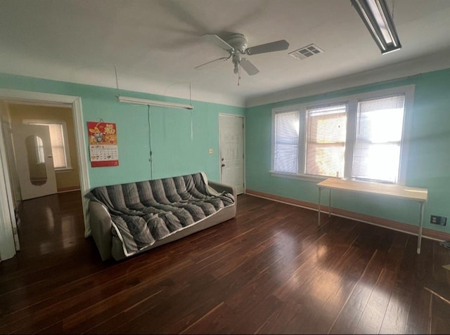 living room featuring visible vents, baseboards, a ceiling fan, and wood finished floors