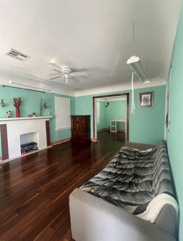 bedroom with wood finished floors, visible vents, and ceiling fan