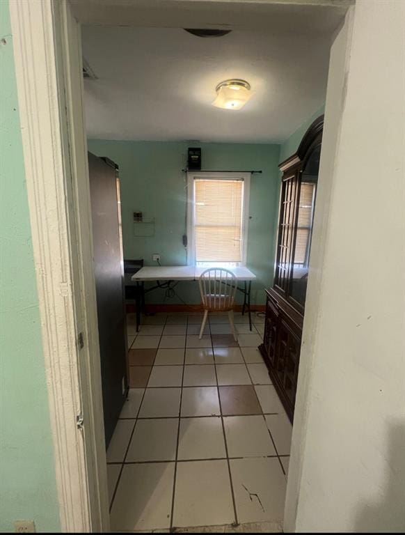 unfurnished dining area featuring light tile patterned floors