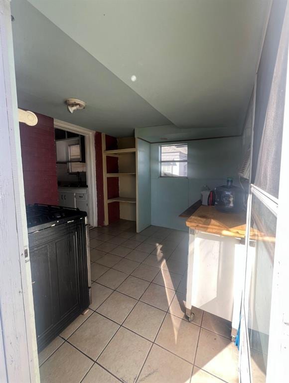 kitchen featuring open shelves and light tile patterned floors