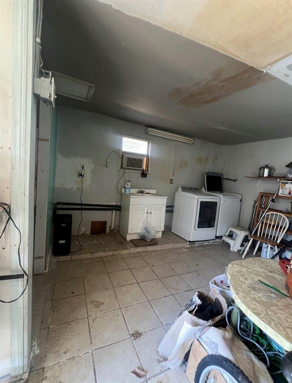 below grade area with light tile patterned floors and separate washer and dryer