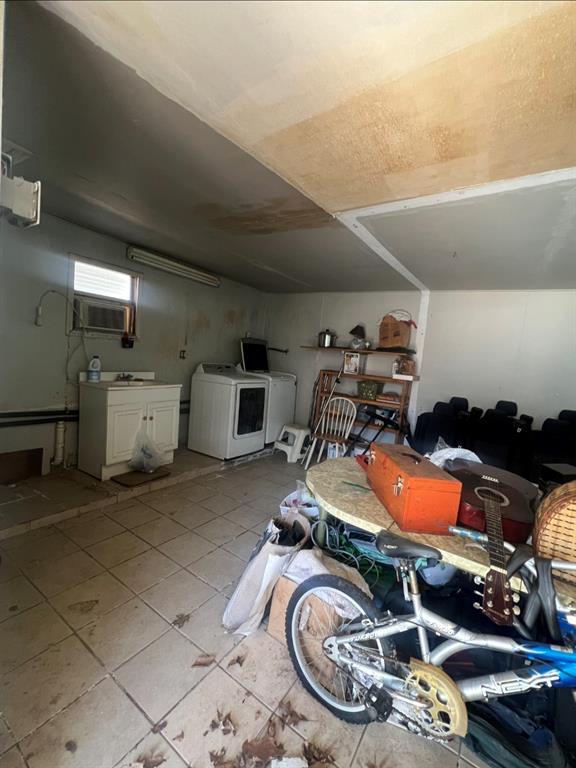 below grade area with light tile patterned floors and washer / clothes dryer