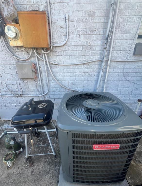 details with brick siding, central AC, and electric meter