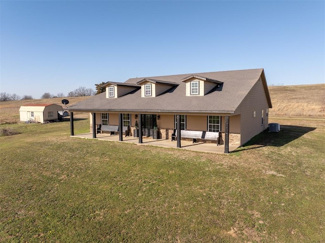 back of property featuring a lawn, cooling unit, and a patio