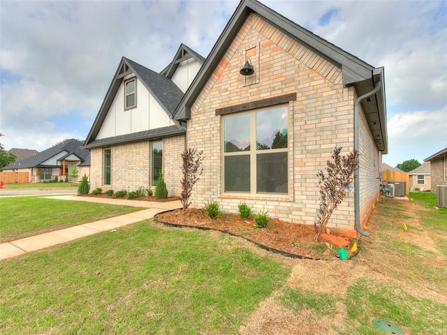 view of front facade featuring cooling unit, brick siding, board and batten siding, and a front lawn