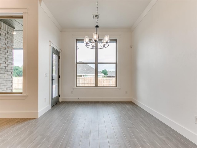 interior space featuring a wealth of natural light, visible vents, a notable chandelier, and light wood-style flooring