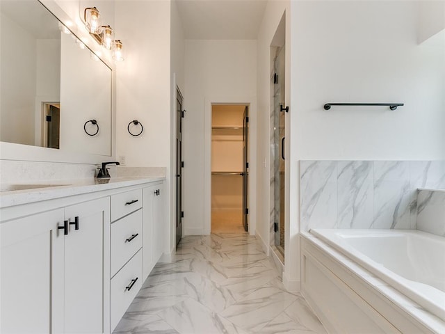 bathroom with vanity, a stall shower, a spacious closet, a garden tub, and marble finish floor