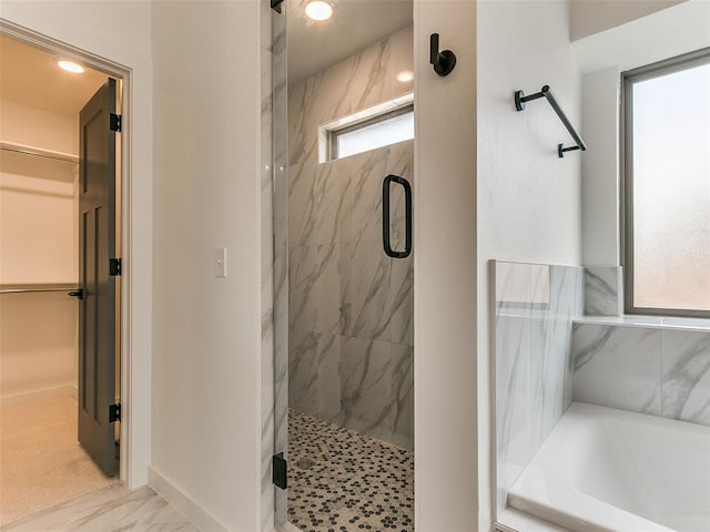 full bathroom featuring a marble finish shower, marble finish floor, a bath, and a walk in closet