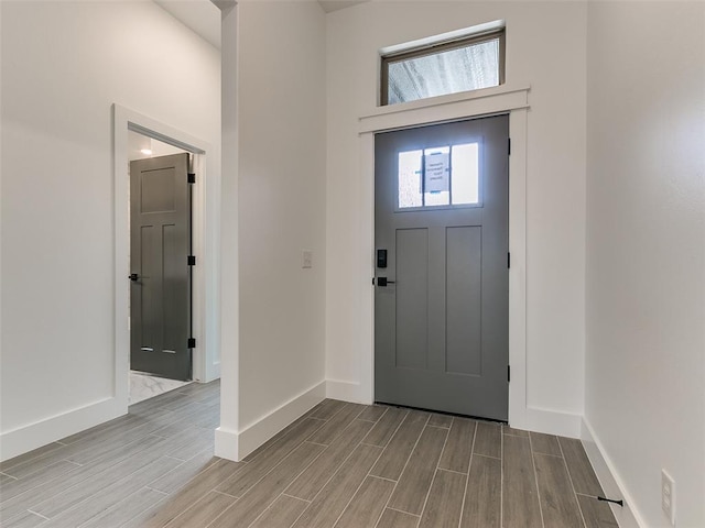 entryway featuring baseboards and wood tiled floor